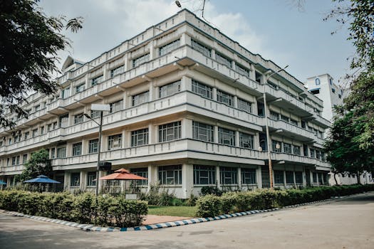Contemporary university building featuring large windows and lush surroundings.